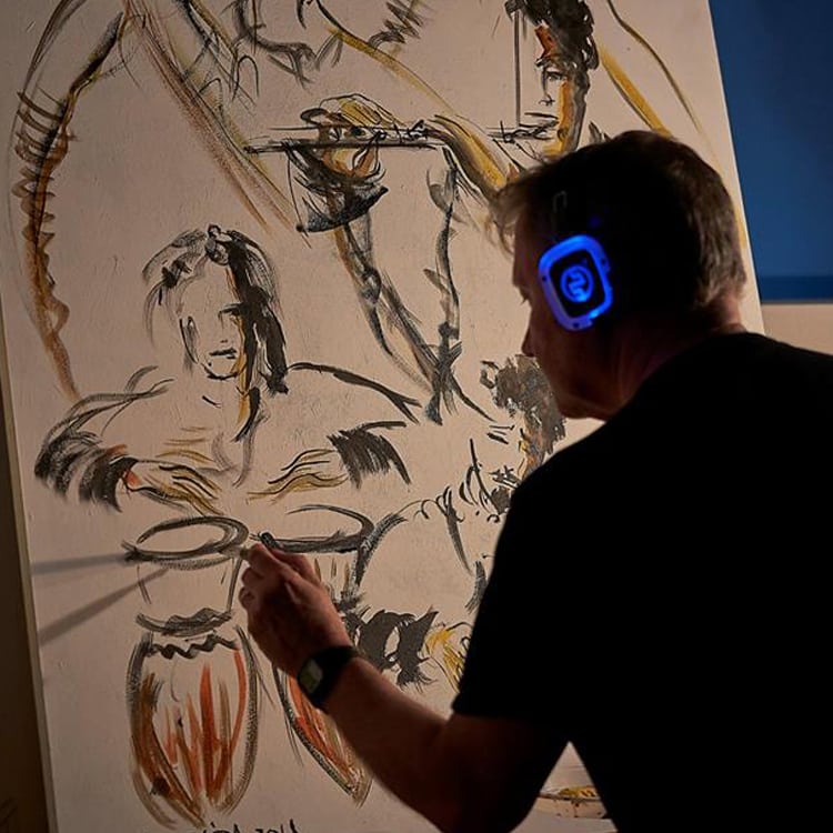live-painting Artist live painting while wearing blue LED wireless headphones