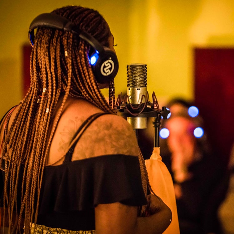 Studi di Registrazione Singer with wireless headphones at the microphone in a recording studio
