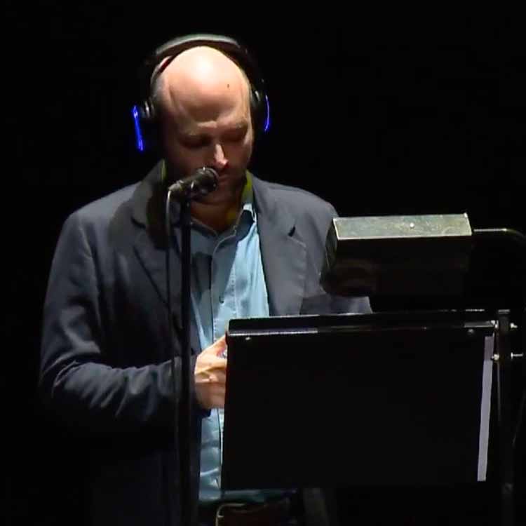 saviano-piccolo-teatro Roberto Saviano reading at a lectern with Silentsystem headphones at the Piccolo Teatro